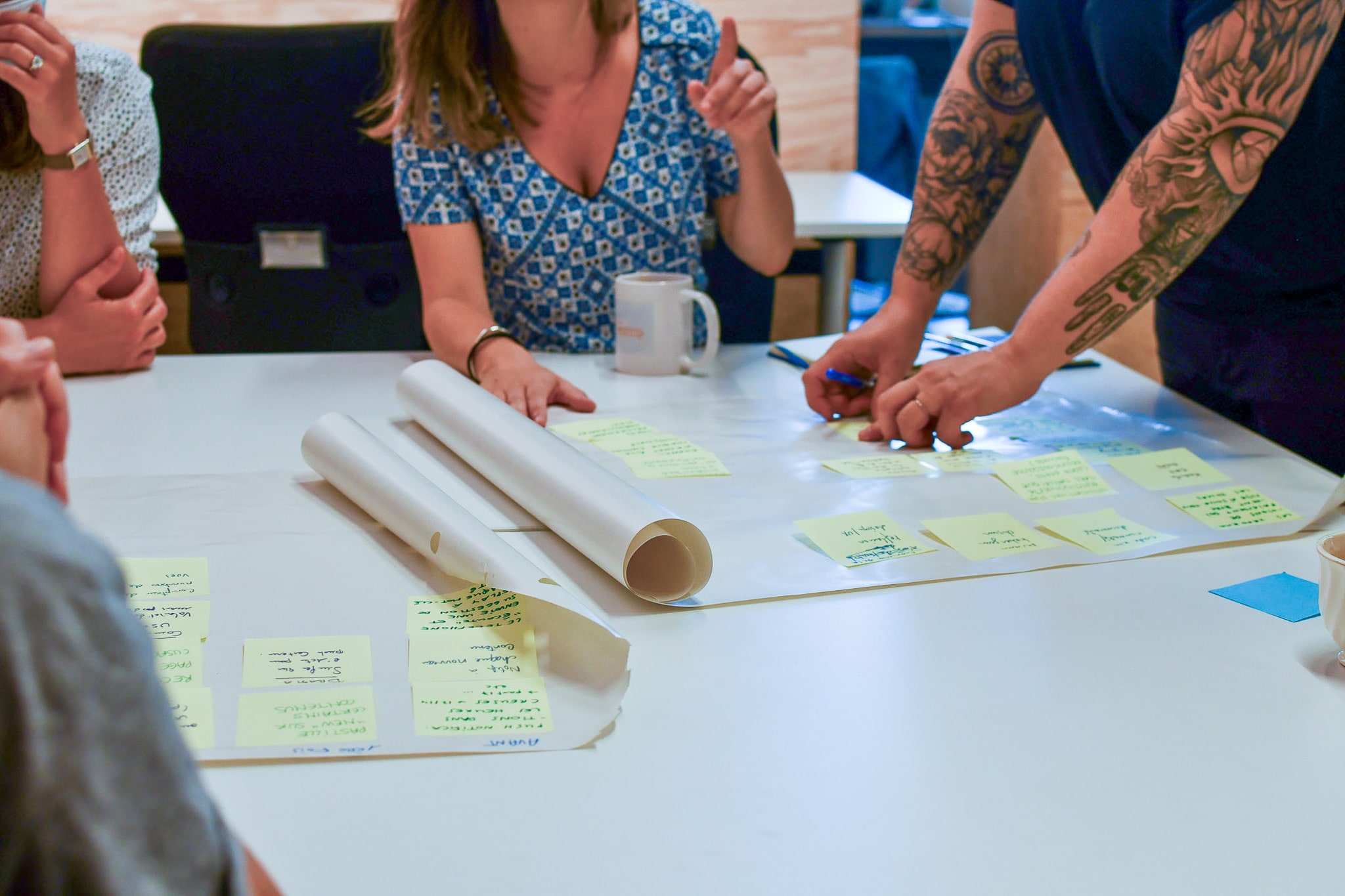 Vu des tables de travail avec des grandes feuilles A3 et post-it
